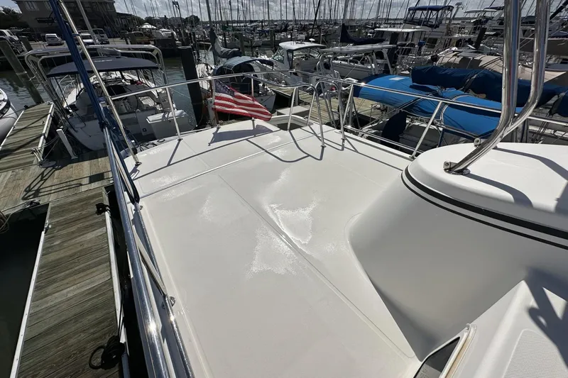 Slide: The Image of 2005 American Tug 34 Pilothouse boat deck with American flag in marina setting. - 96