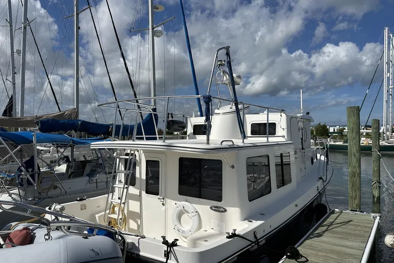 Slide: The Image of 2005 American Tug 34 Pilothouse docked at marina under blue sky. - 97