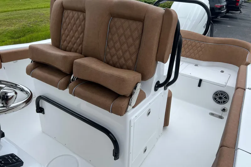 Slide: The Image of 2026 Sea Hunt Ultra 255 SE boat interior with brown cushioned seating and steering wheel. - 12