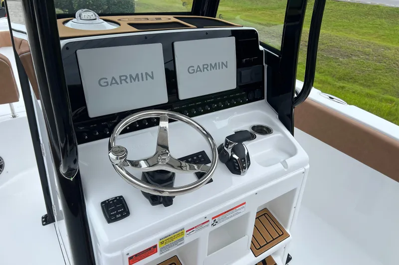 Slide: The Image of 2026 Sea Hunt Ultra 255 SE boat dashboard with Garmin displays and steering wheel. - 13