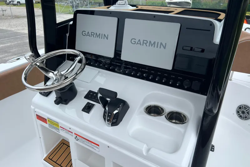 Slide: The Image of 2026 Sea Hunt Ultra 255 SE boat dashboard with dual Garmin displays and steering wheel. - 14