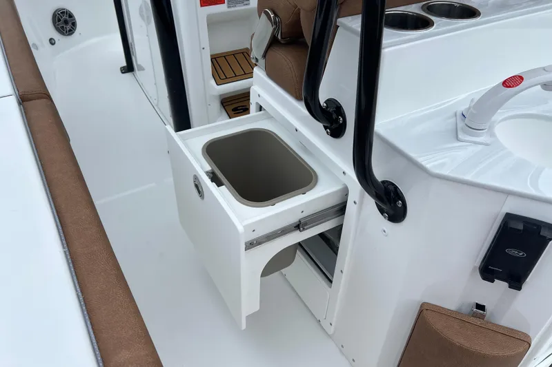 Slide: The Image of 2026 Sea Hunt Ultra 255 SE boat interior with open storage compartment and sink. - 22