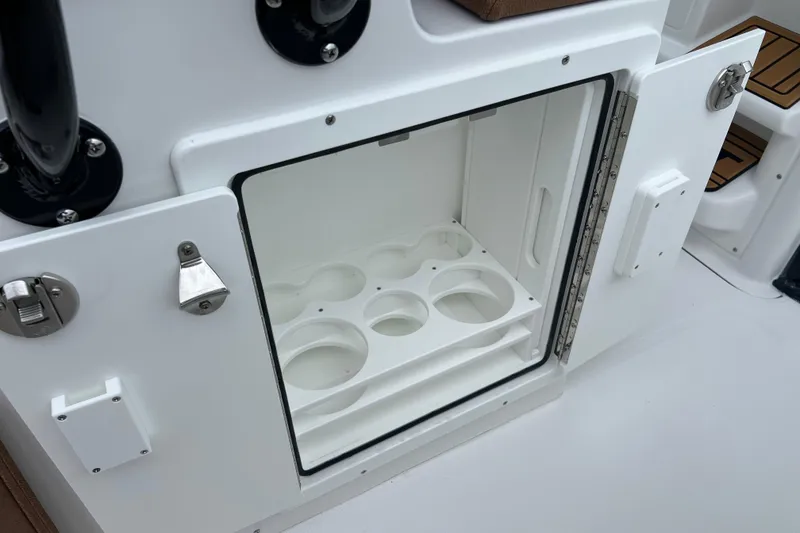 Slide: The Image of Open storage compartment on 2026 Sea Hunt Ultra 255 SE boat, featuring cup holders. - 24