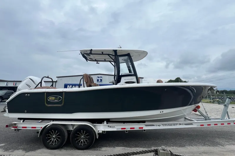 Slide: The Image of 2026 Sea Hunt Ultra 255 SE boat on trailer, side view, overcast sky. - 3