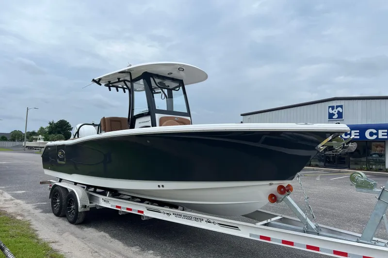Slide: The Image of 2026 Sea Hunt Ultra 255 SE boat on trailer, parked outside a marine service center. - 4