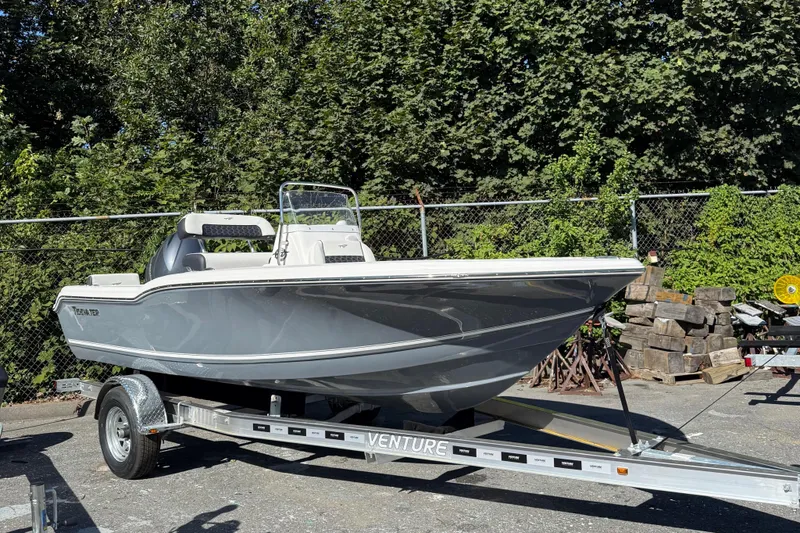 The Image of 2026 Tidewater 180CC boat on trailer, parked outdoors with trees in background. - 0
