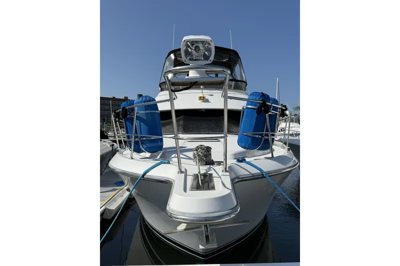 Slide: The Image of 1993 Carver 350 Motor Yacht docked, front view with blue fenders, clear sky background. - 1