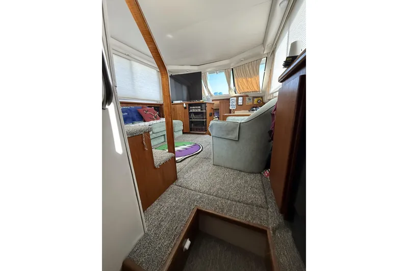Slide: The Image of Interior of 1993 Carver 350 Motor Yacht with cozy seating and carpeted flooring. - 13