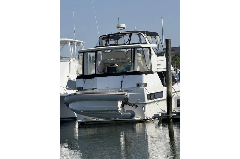 Slide: The Image of 1993 Carver 350 Motor Yacht docked at marina, rear view with inflatable boat attached. - 4