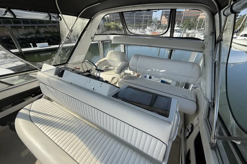 Slide: The Image of Interior of 1993 Carver 350 Motor Yacht with white seating and marina view. - 6