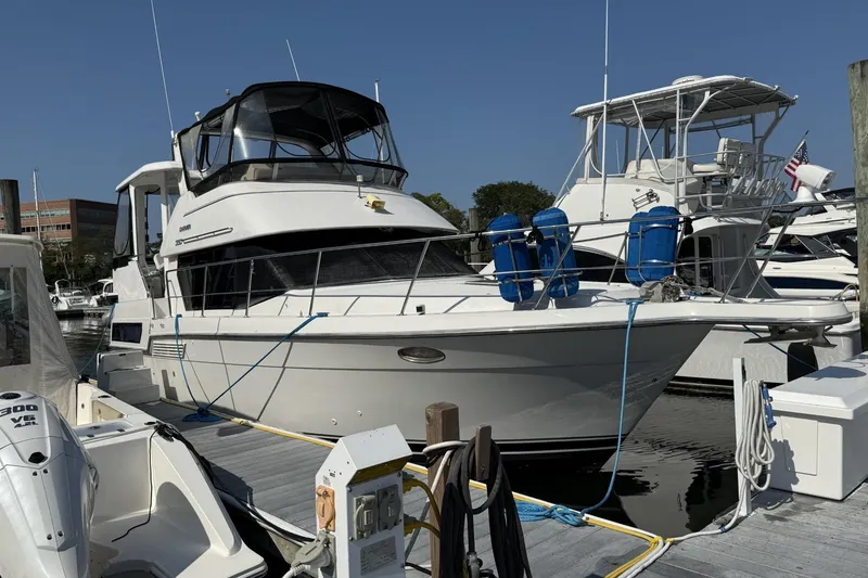 Slide: The Image of 1993 Carver 350 Motor Yacht docked at marina, clear sky, other boats nearby. - 3