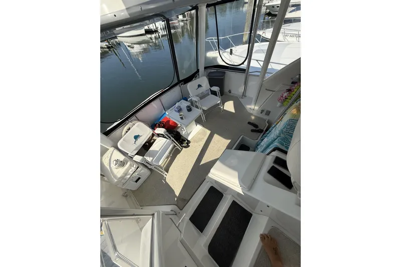 Slide: The Image of 1993 Carver 350 Motor Yacht interior with chairs and table, docked at marina. - 7