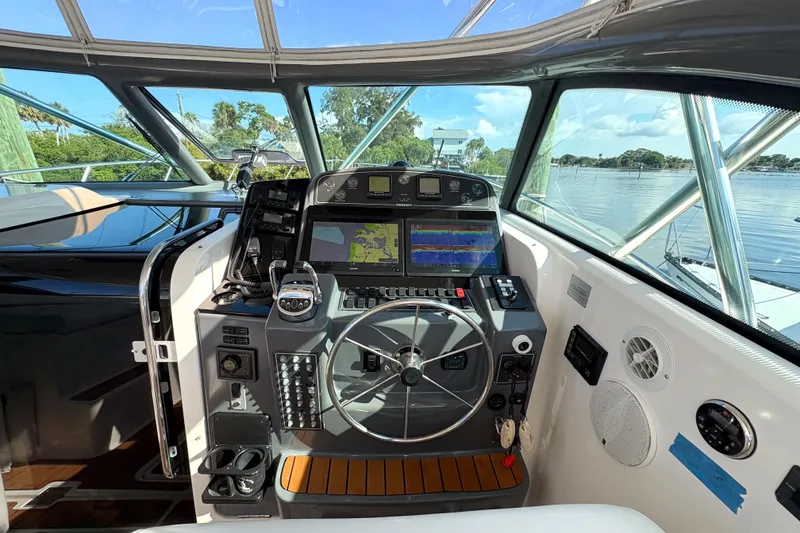 Slide: The Image of Cockpit of 2002 Pursuit 3800 Express boat with navigation equipment and steering wheel. - 16