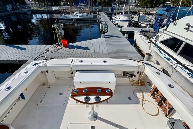 Slide: The Image of 2002 Pursuit 3800 Express boat docked at marina, featuring spacious deck and fishing setup. - 18