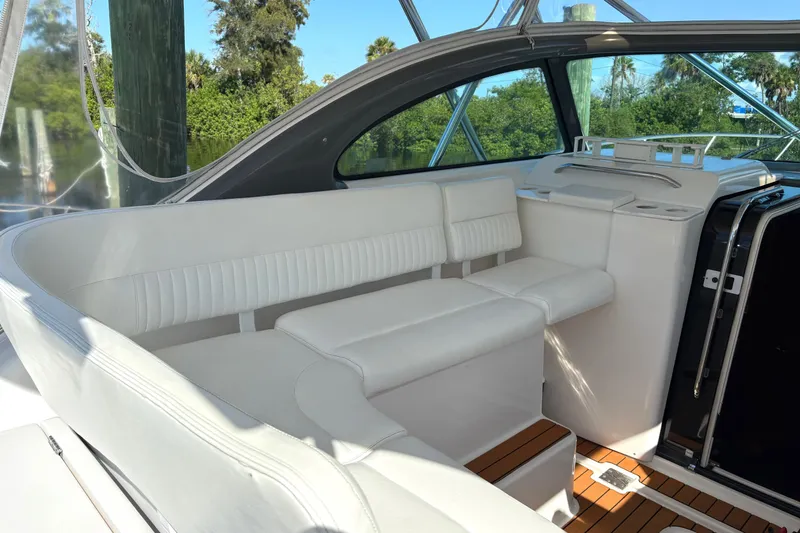 Slide: The Image of Luxurious white seating area on a 2002 Pursuit 3800 Express yacht, surrounded by nature. - 6