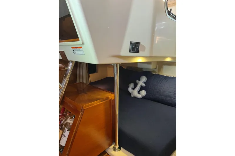 Slide: The Image of Interior of 2009 Pursuit OS 375 Offshore boat with anchor pillow on navy bedding. - 14
