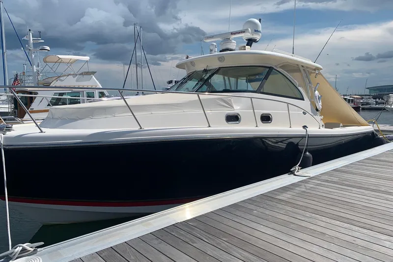 Slide: The Image of 2009 Pursuit OS 375 Offshore boat docked at marina under cloudy sky. - 2
