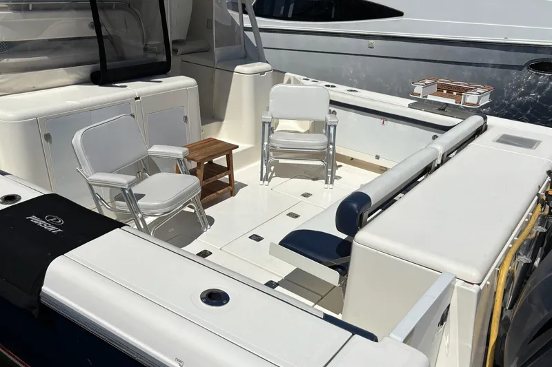 Slide: The Image of 2009 Pursuit OS 375 Offshore boat deck with chairs and table, showcasing spacious seating area. - 20