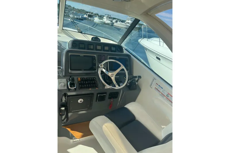 Slide: The Image of 2009 Pursuit OS 375 Offshore helm with steering wheel and navigation controls. - 3