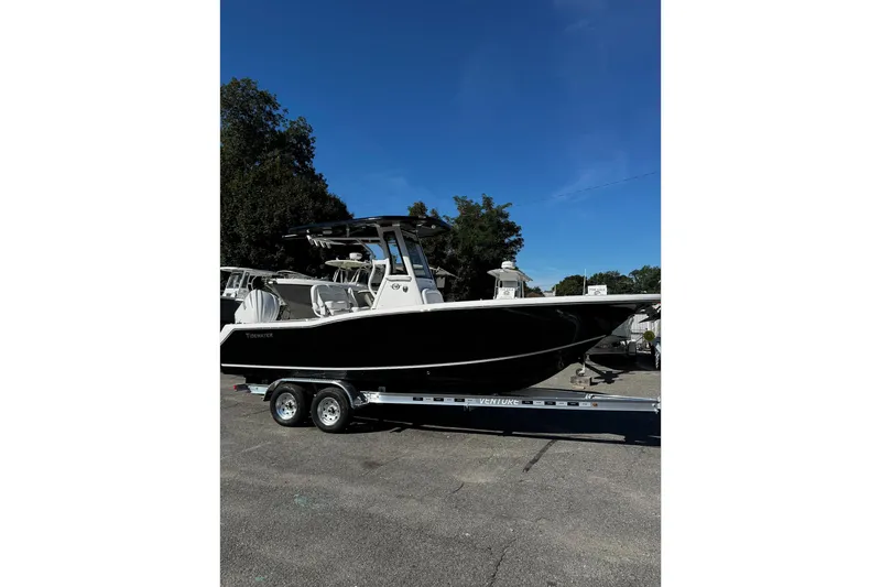 The Image of 2026 Tidewater 232 CC Adventure boat on trailer under clear blue sky. - 0