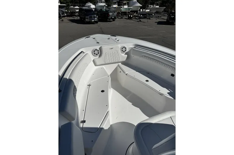 Slide: The Image of 2026 Tidewater 232 CC Adventure boat interior with seating and console, docked outdoors. - 13