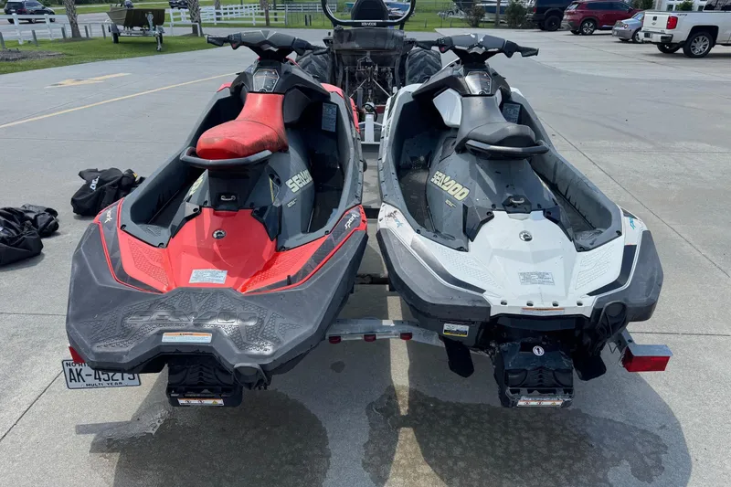 Slide: The Image of Two 2017 Sea-Doo Spark 2up jet skis on a trailer in a parking lot. - 4