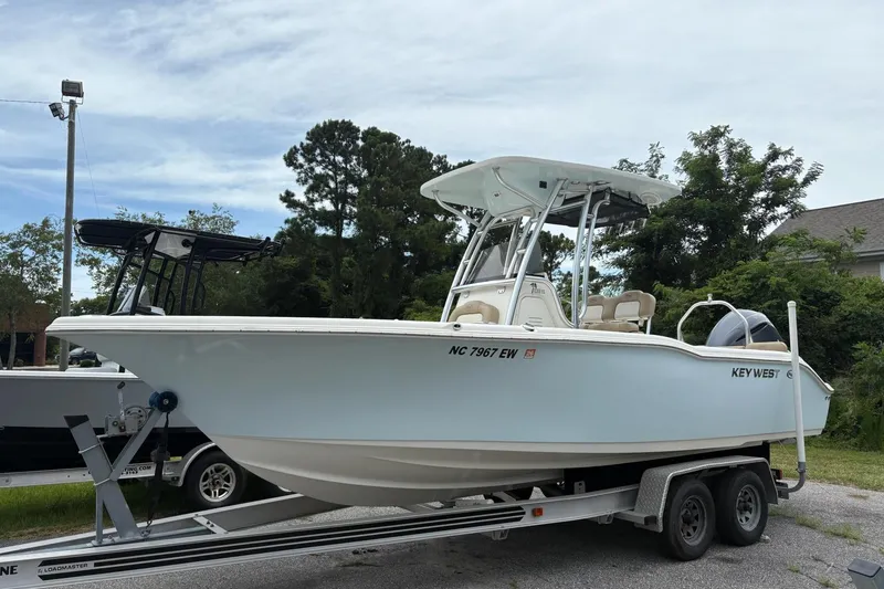The Image of 2018 Key West 239 FS boat on trailer, parked outdoors with trees in background. - 1