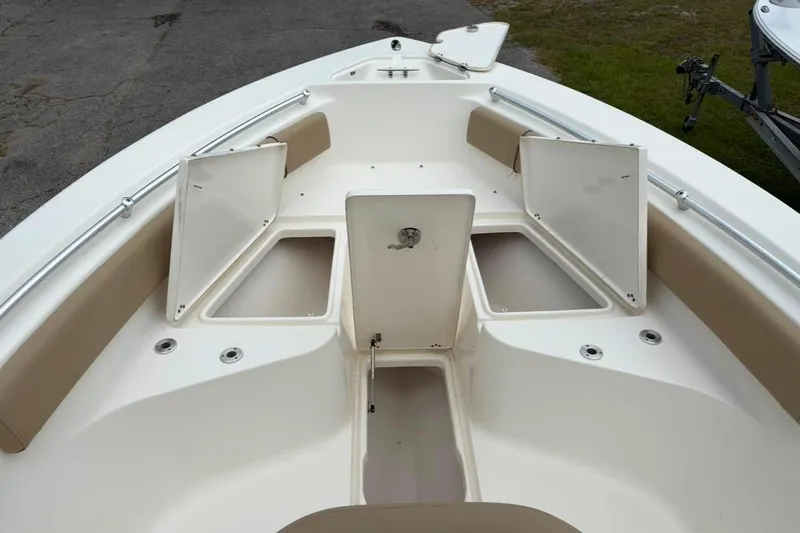 Slide: The Image of 2018 Key West 239 FS boat interior with open storage compartments and cushioned seating. - 16