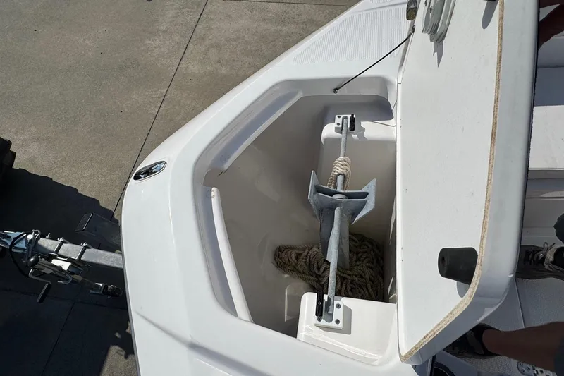 Slide: The Image of Open anchor compartment on 2018 Yamaha Boats 210 FSH, showing anchor and rope storage. - 11