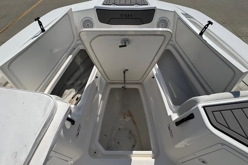 Slide: The Image of Open storage compartments on a 2018 Yamaha Boats 210 FSH, showcasing spacious interior. - 13