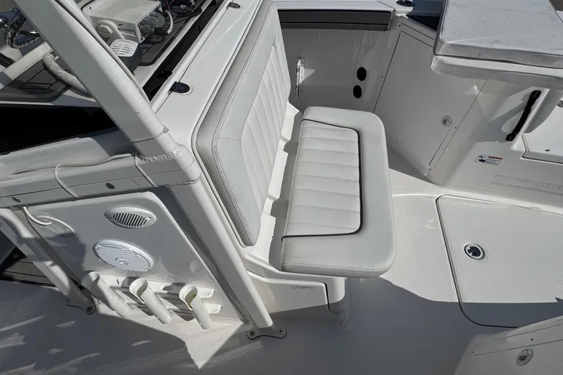 Slide: The Image of 2018 Yamaha Boats 210 FSH interior with seating and storage compartments. - 14
