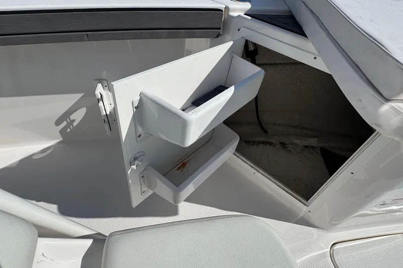 Slide: The Image of Open storage compartment on 2018 Yamaha Boats 210 FSH, featuring built-in shelves. - 15