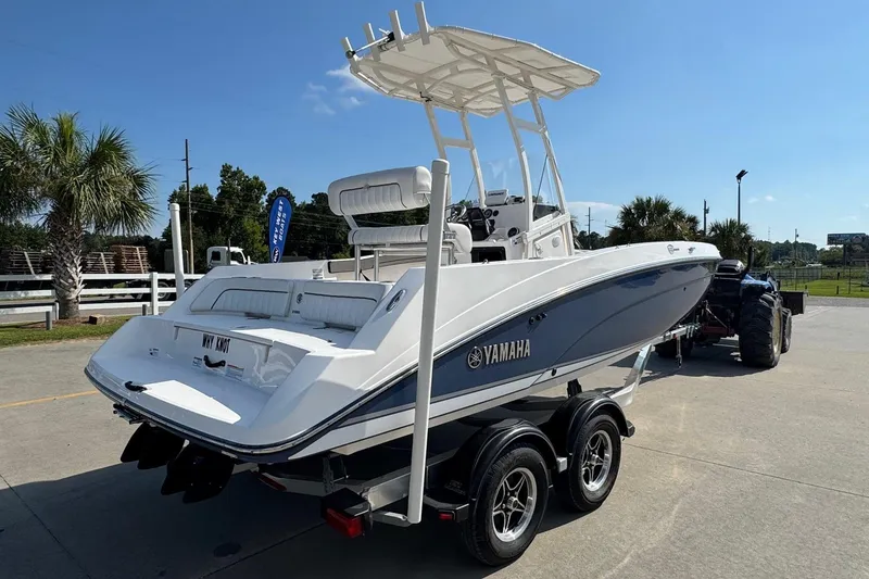 Slide: The Image of 2018 Yamaha Boats 210 FSH on trailer, parked outdoors under clear blue sky. - 2
