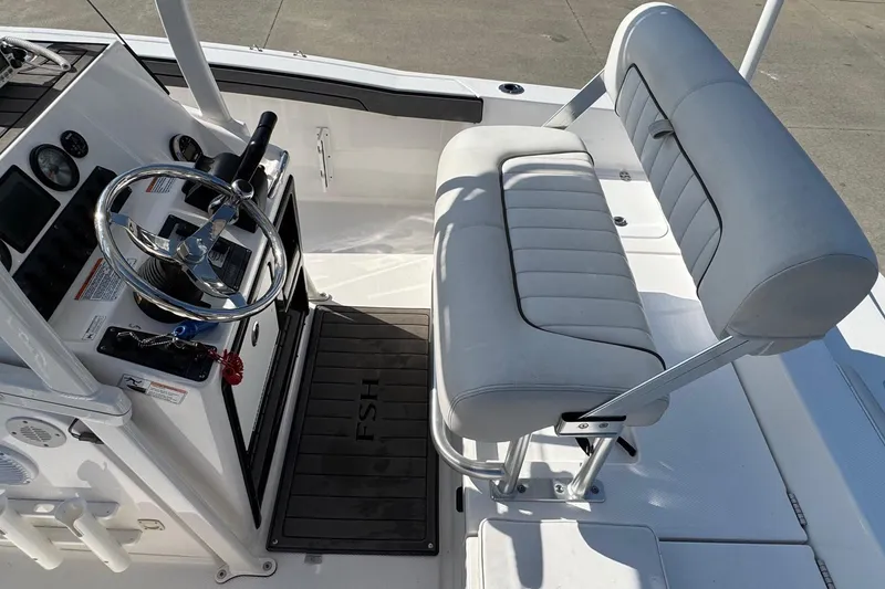 Slide: The Image of 2018 Yamaha Boats 210 FSH interior with steering wheel and cushioned seating. - 20