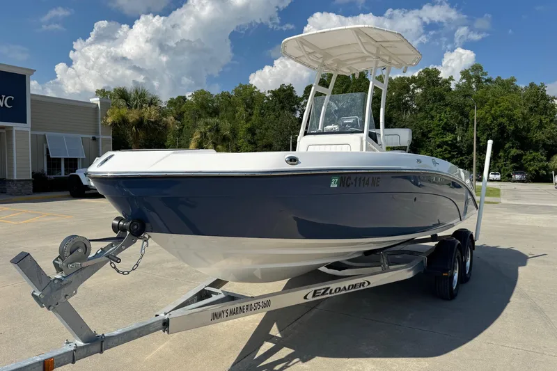 Slide: The Image of 2018 Yamaha Boats 210 FSH on trailer, parked outdoors under a cloudy sky. - 5
