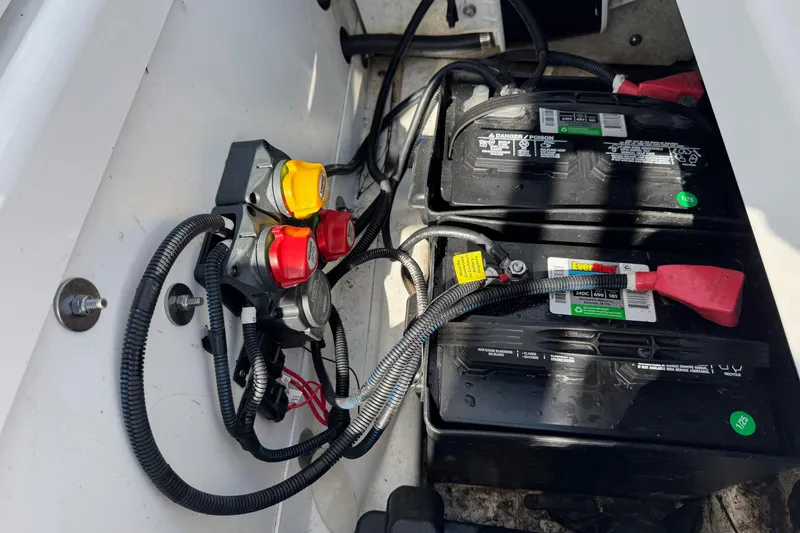 Slide: The Image of 2018 Yamaha Boats 210 FSH battery compartment with wiring and switches. - 8