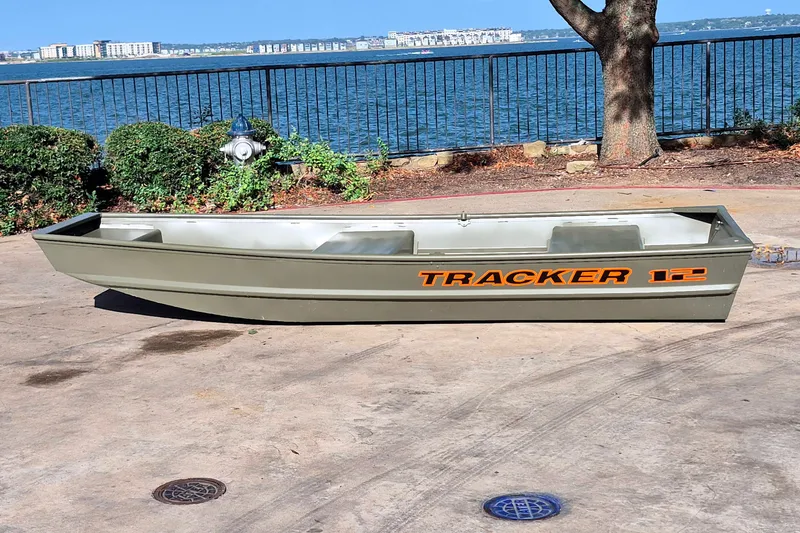 The Image of 2026 Tracker Grizzly 12 Jon boat on concrete near waterfront. - 0