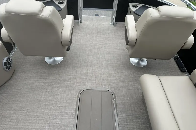 Slide: The Image of Interior of 2025 Sun Tracker Sportfish 24 XP3 with beige seating and carpeted floor. - 9