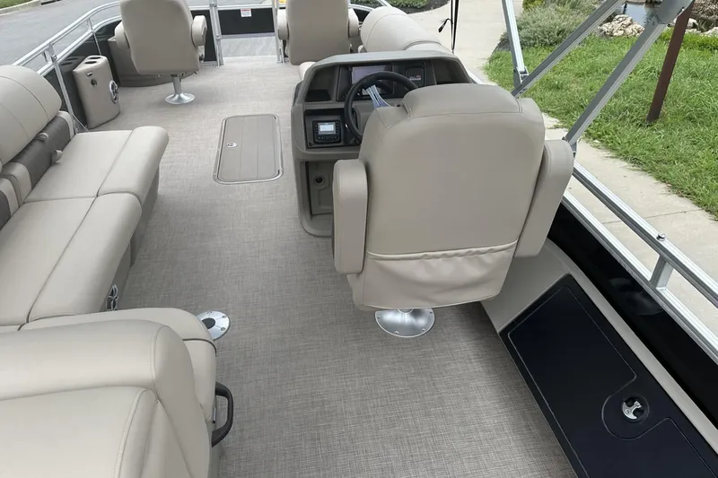 Slide: The Image of 2025 Sun Tracker Sportfish 24 XP3 interior with beige seating and steering console. - 25