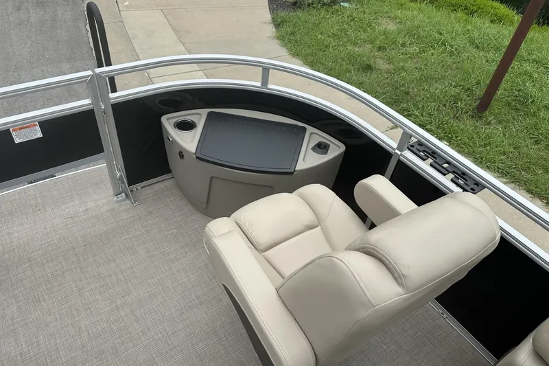 Slide: The Image of 2025 Sun Tracker Sportfish 24 XP3 boat interior with beige seating and control panel. - 11
