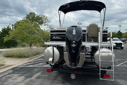 Slide: The Image of 2025 Sun Tracker Sportfish 24 XP3 pontoon boat with 150 HP engine in parking lot. - 2