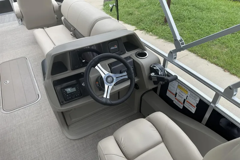Slide: The Image of 2025 Sun Tracker Sportfish 24 XP3 boat interior with steering wheel and seating. - 18
