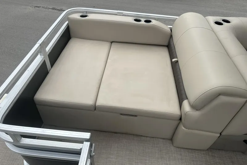 Slide: The Image of 2025 Sun Tracker Sportfish 24 XP3 boat seating area with beige upholstery and cup holders. - 27