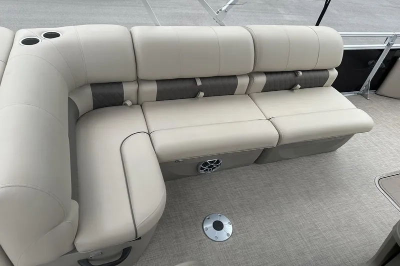 Slide: The Image of 2025 Sun Tracker Sportfish 24 XP3 boat interior with beige cushioned seating and cup holders. - 22