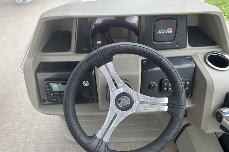 Slide: The Image of Steering console of 2025 Sun Tracker Sportfish 24 XP3 boat with controls and logo. - 19