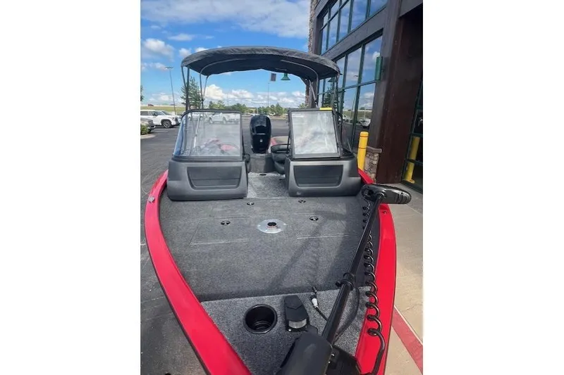 Slide: The Image of 2026 Tracker Pro Guide V-16 WT boat with red exterior, dual windshields, and trolling motor. - 2