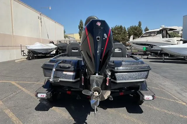 Slide: The Image of 2026 Nitro Z21 XL Pro boat, rear view, parked outdoors in a marina setting. - 5