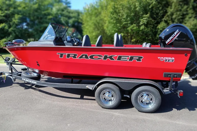The Image of 2026 Tracker Targa V-18 Combo boat on trailer, vibrant red, parked outdoors. - 0
