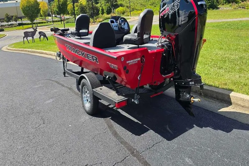 Slide: The Image of 2026 Tracker Pro Team 190 boat on trailer, red exterior, parked on asphalt. - 3