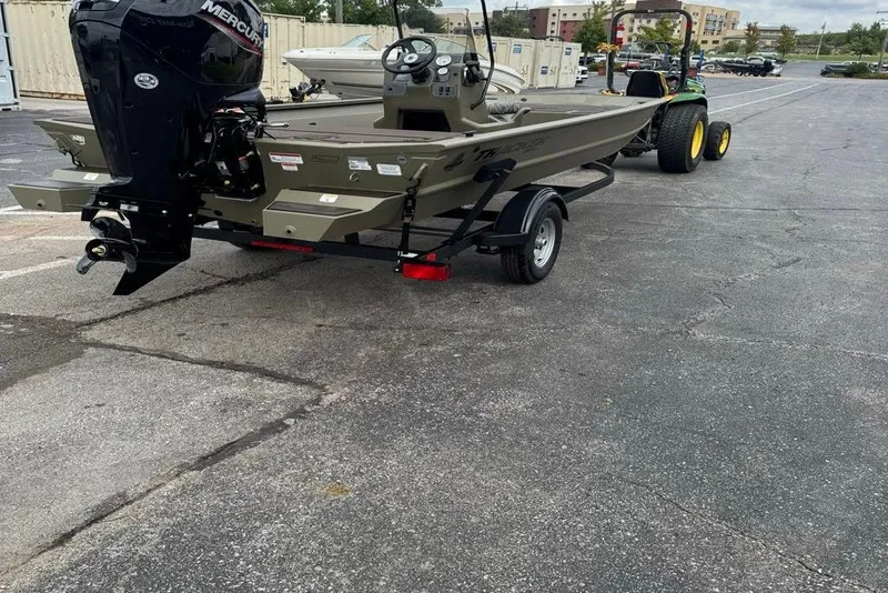 Slide: The Image of 2026 Tracker Grizzly 1860 CC boat on trailer, parked outdoors. - 2